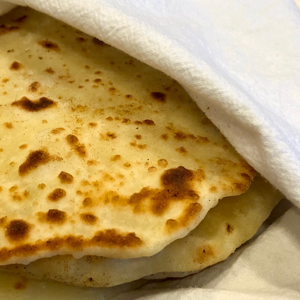 Several pieces of Quick Yogurt Flatbread wrapped in a tea towel