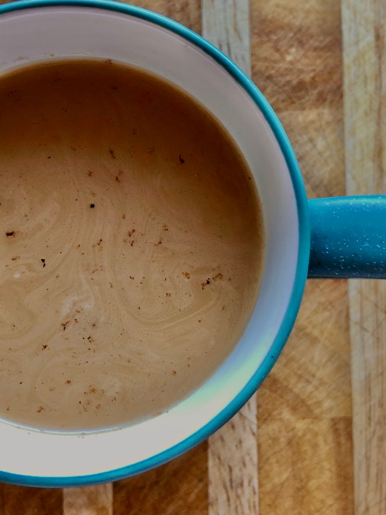 Closeup of Dandelion Tea Latte in a mug, topped with spices
