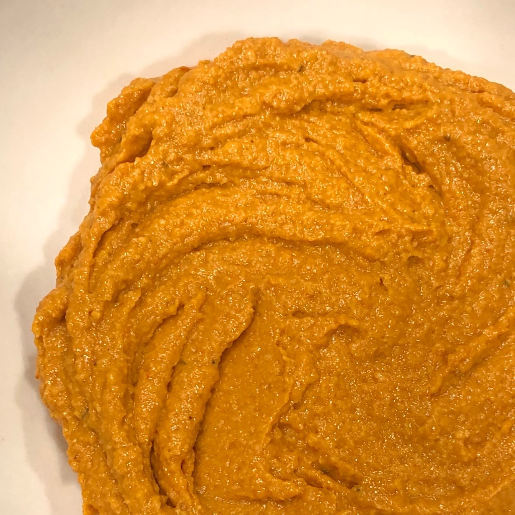 Romesco sauce—a thick, warm orange sauce in a bowl